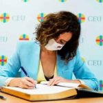 La presidenta firmando en el libro de honor del CEU. (Foto: CdeM/IsabelDíazAyuso)