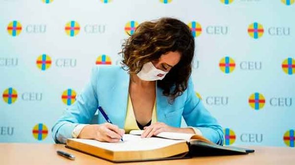 La presidenta firmando en el libro de honor del CEU. (Foto: CdeM/IsabelDíazAyuso)