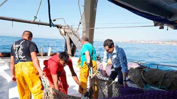Juanma Moreno con el patrón y los tripulantes del Pedro Benzal que han salido a faenar en la costa de Fuengirola. (Foto: @JMM)
