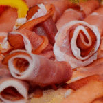 Un aperitivo de jamón serrano con aguacate sobre tostadas con ajo Un aperitivo de jamón serrano con aguacate sobre tostadas con ajo
