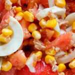 Una ensalada de atún, maíz, tomate, embutido y queso para una cena ligera y sana